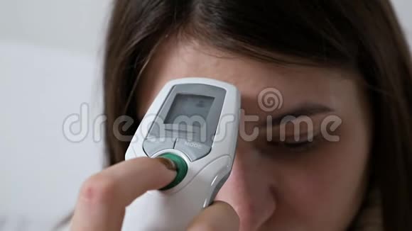 女孩用电子医用红外温度计检查温度保健和医疗概念视频的预览图