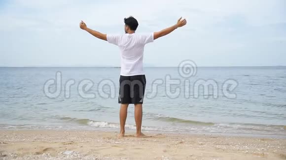 放松亚洲男子赤脚在热带夏季海滩散步感受新鲜和自由的假期享受赤脚在户外行走的乐趣视频的预览图