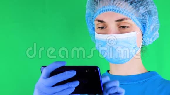 女医生拿着绿色屏幕的手机对着相机合成视频的预览图