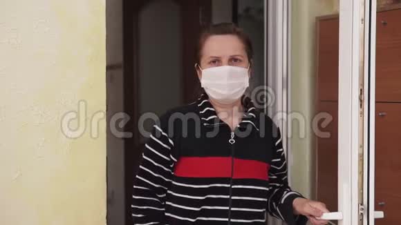 一个戴着医用口罩的女人走进屋子关上了门视频的预览图