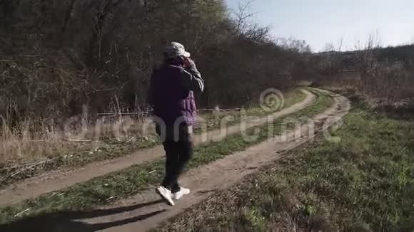 一位年轻女子走在乡间小路上视频的预览图
