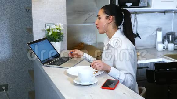 快乐的西班牙妇女完成厨房笔记本电脑的工作视频的预览图
