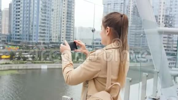 4k段女子站在天台的视频拍摄城市天际线和剪报并在社交媒体上刊登视频的预览图
