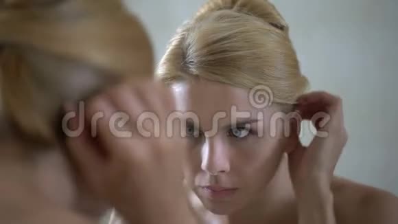 不安全的漂亮女士在皮肤上弹出粉刺仔细检查她的镜子反射视频的预览图