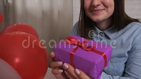 一个微笑的女人拿着一个礼物盒很高兴认为那里情人节概念视频的预览图