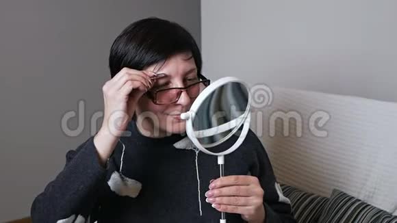 一位年长的女士用镊子夹住眉毛视频的预览图