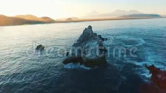 鸟瞰图照相机在岛上的海鸟的岩石上飞来飞去摄像机变焦视频的预览图