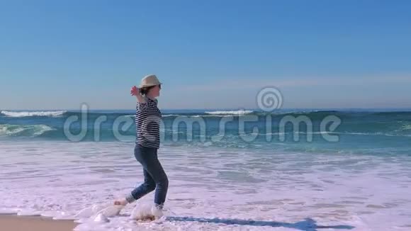 女人快乐双臂向上舞动在沙滩上假日旅行视频的预览图