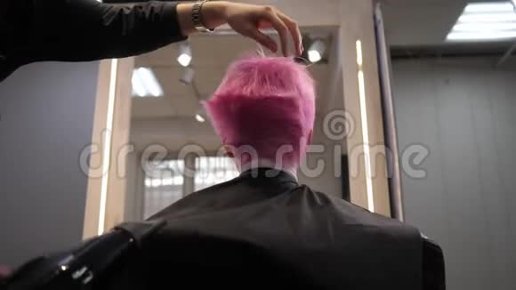 粉红色的短发在发廊里吹干从下面的后视镜慢动作视频的预览图