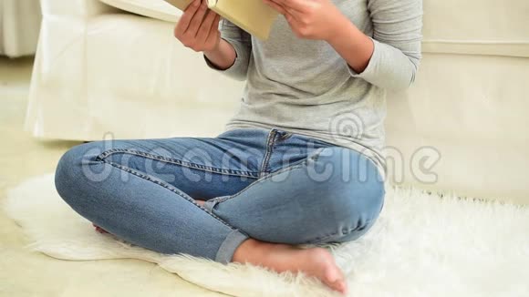 亚洲女人在温暖的家里舒适的沙发上看书视频的预览图