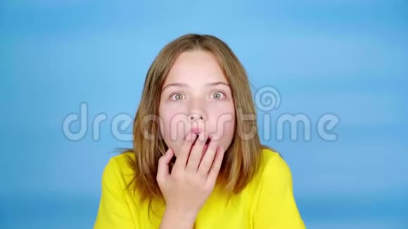 穿黄色T恤的少女用手捂住嘴非常惊讶视频的预览图