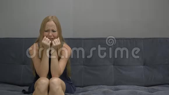 一个年轻的女人坐在沙发上男人感到心烦意乱右侧复制空间视频的预览图