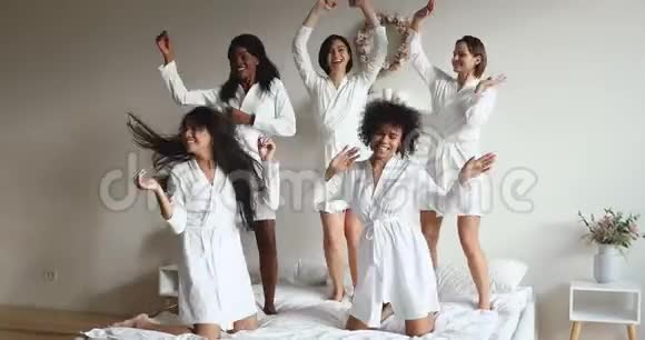快乐的各种女孩朋友穿着睡衣在床上跳舞视频的预览图