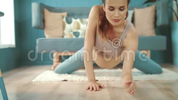 关闭年轻孕妇练习瑜伽肚皮妈妈在地板上伸展视频的预览图