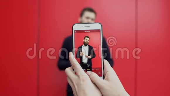在电话里用红色背景拍摄了一段与会说话的黑发胡子男人的视频是谁的手视频的预览图