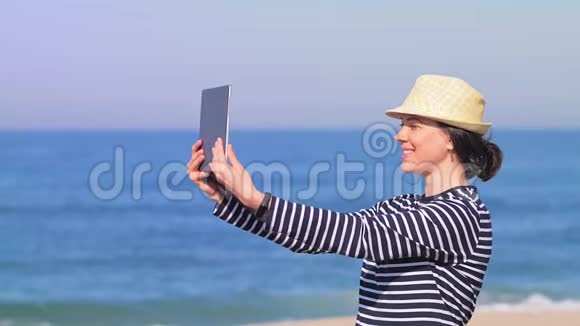 快乐的女人在阳光明媚的海滩上和朋友们聊天视频的预览图