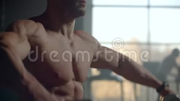 一个没有t恤的人把哑铃举到窗前做肩部肌肉锻炼健美运动员视频的预览图