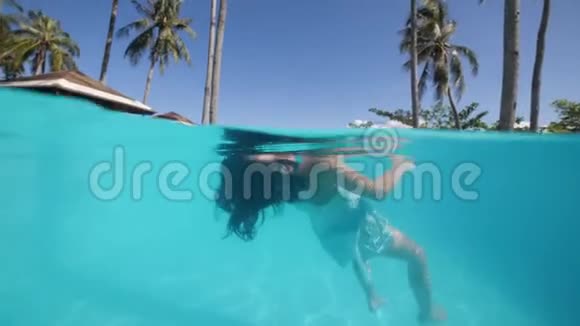 小女孩在浮潜面具潜水和水下游泳在游泳池在酒店视频的预览图