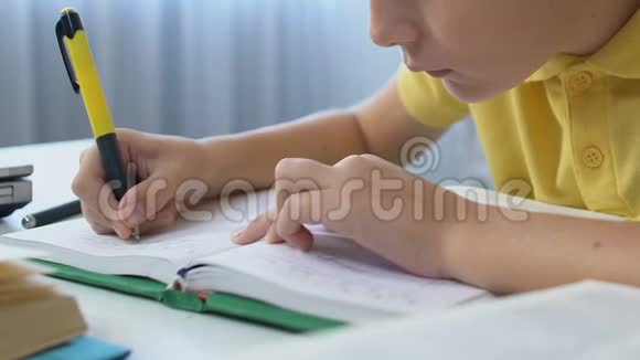 专心致志的男孩在放学后用笔记本写家务活教育视频的预览图