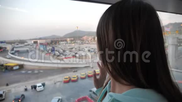 年轻的白种人女性旅行者从终点站的窗口望出去期待着4K的冒险视频的预览图