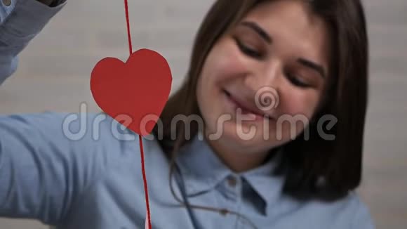 情人节那天一个年轻漂亮的女孩在公寓里准备心脏装饰品视频的预览图