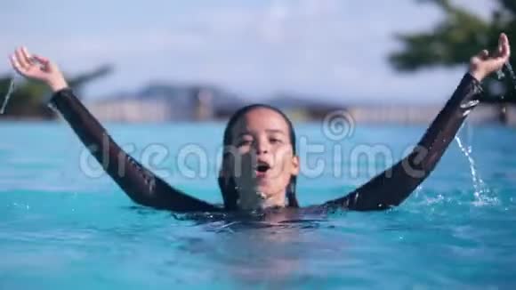 快乐的亚洲女孩微笑着在热带岛屿上的游泳池里跳跃度假视频的预览图