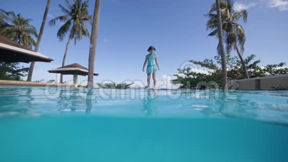可爱的小女孩跳进游泳池游泳把她的玩具带到水下视频的预览图
