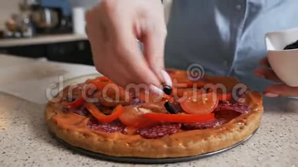 在家做意大利披萨一个女孩把橄榄放在披萨上视频的预览图