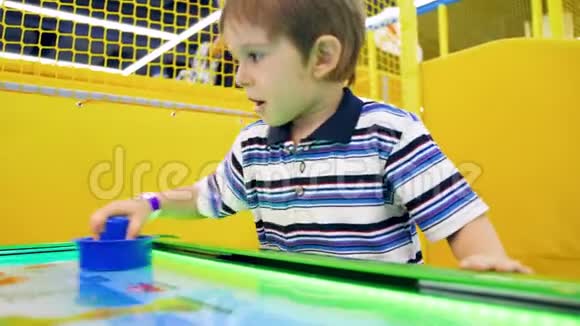 快乐小男孩在游乐园玩曲棍球的4k视频视频的预览图