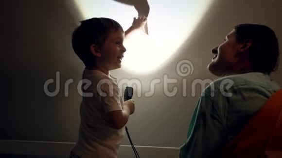 4k小男孩和小妈妈睡觉前在卧室墙上玩影子游戏的视频视频的预览图