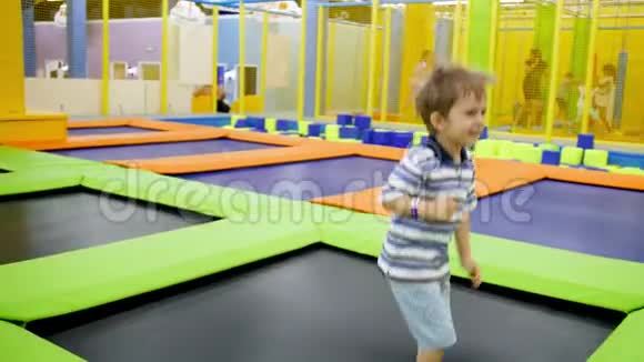 快乐的小男孩在购物中心蹦蹦跳跳的时候玩得开心快乐的视频视频的预览图