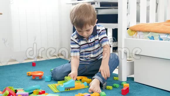 四岁小男孩在房间里玩玩具的视频以五颜六色的儿童建筑和装配视频的预览图