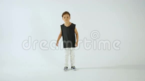 穿着黑色T恤跳舞玩得开心的小男孩在白色上孤独视频的预览图