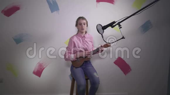 白人少女用挂着的麦克风和设备唱一首歌视频的预览图