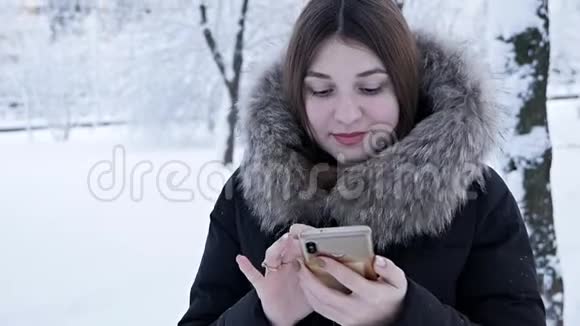 一个女人在寒冷的冬天打电话冬天下雪视频的预览图