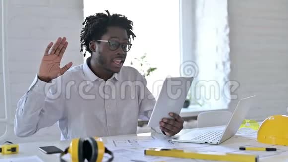 年轻的非洲建筑工程师在办公室的平板电脑上进行视频聊天视频的预览图