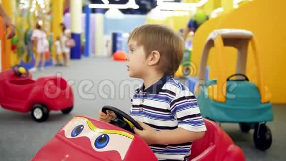 在购物中心的游乐园里小男孩骑着脚踏车的儿童车视频的预览图