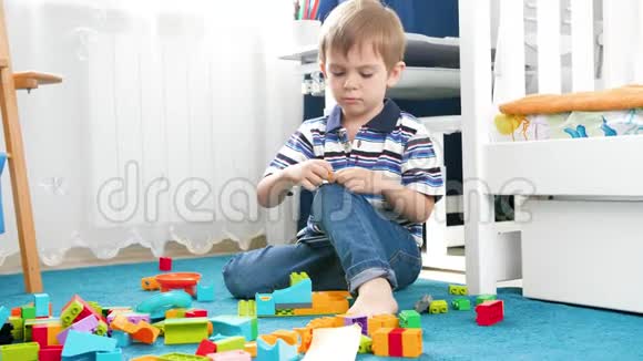 4k视频聪明的幼儿男孩在他的房间里玩五颜六色的玩具砖和积木视频的预览图