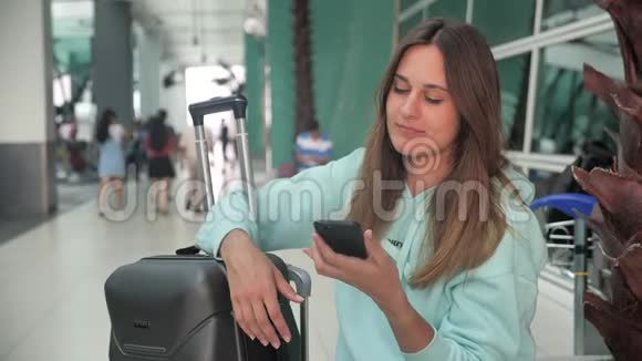 在机场休息室等飞机的乘客白种人女人在候诊室打电话视频的预览图