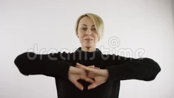 白种人成年中年白种人金发短毛妇女伸展手指准备在白色背景下工作视频的预览图