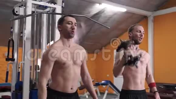 两个人在体育俱乐部举重特写男在健身房用哑铃训练肌肉视频的预览图