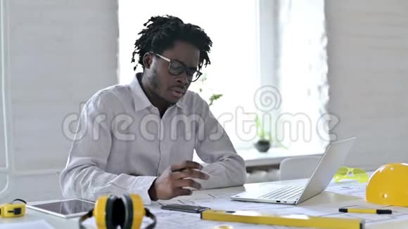 有笔记本电脑的非洲建筑工程师在办公室做文书工作视频的预览图