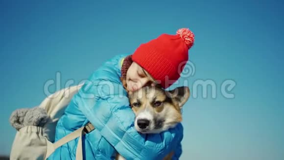 阳光明媚的春日爱抚爱犬散步的年轻女子视频的预览图