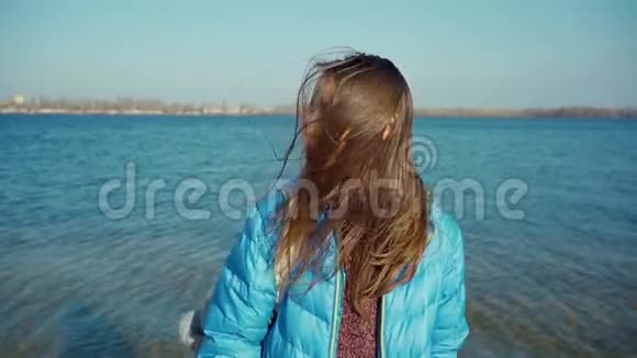 肖像女子走在海边阳光明媚风吹头发视频的预览图
