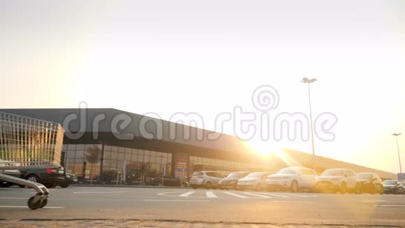 日落时分年轻女子骑着购物车在停车场上欢快微笑的视频视频的预览图
