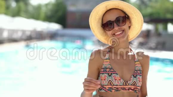 戴着帽子戴着太阳镜的白种人快乐的女人手里拿着相机微笑视频的预览图