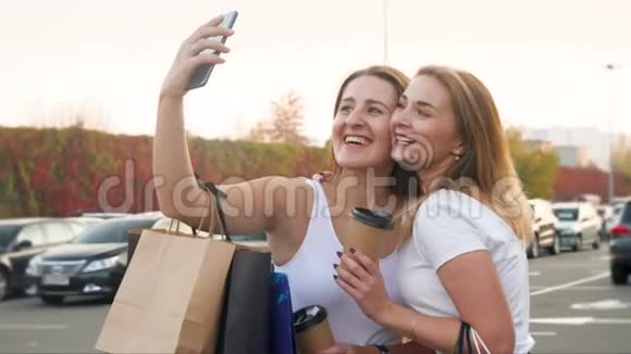 两个滑稽的微笑和笑的女孩在智能手机上自拍后做鬼脸的4k视频视频的预览图