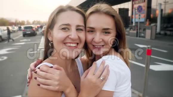 在停车场和购物中心自拍时两个快乐的笑女孩朋友拥抱和拥抱的视频视频的预览图