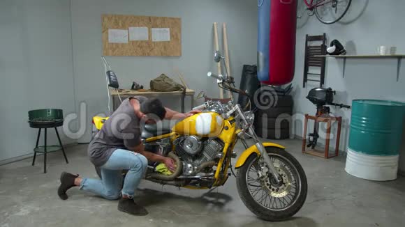年轻人在车库里用抹布擦摩托车视频的预览图