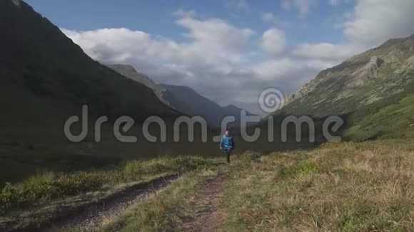 在山里行走的男性背包客视频的预览图
